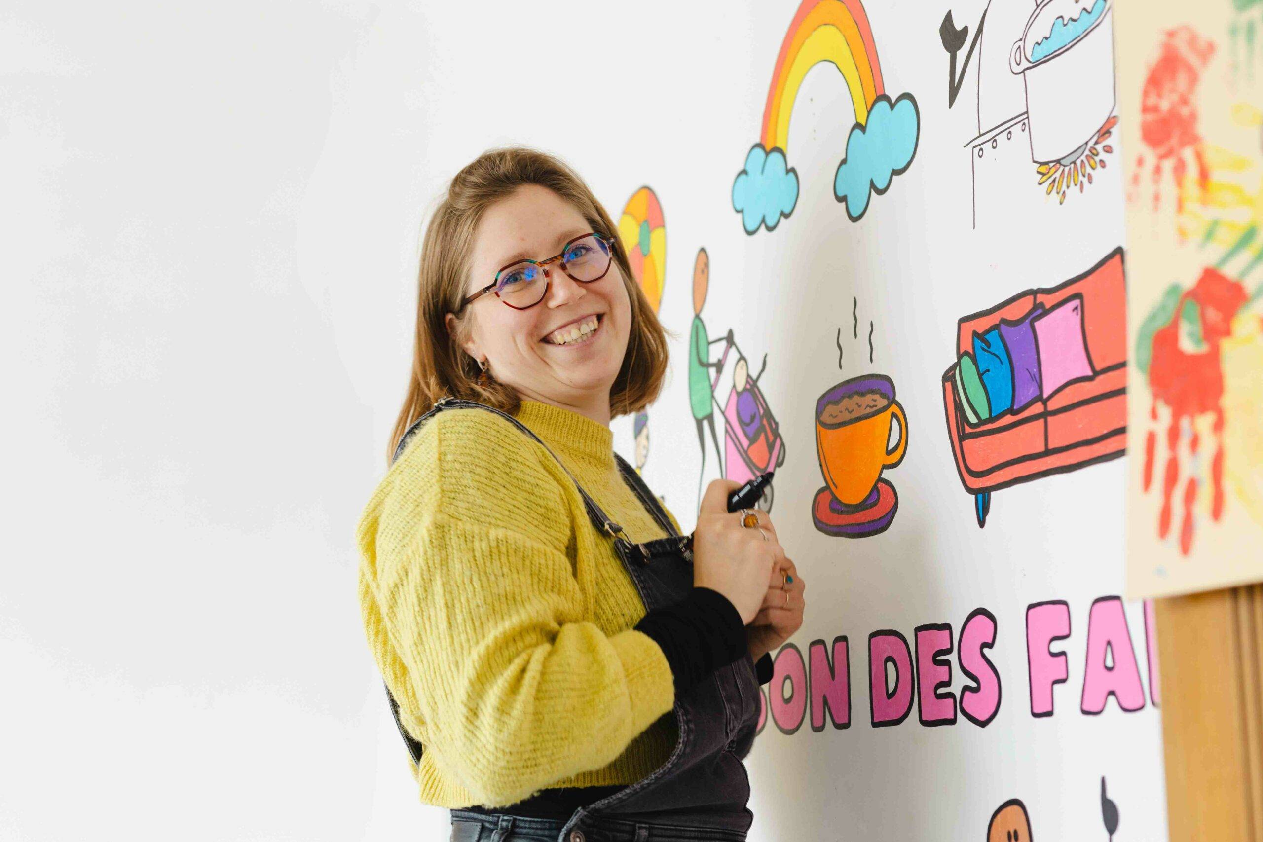 Portrait de Solène Boggio travailleuse sociale, en train de retoucher la fresque réalisée par les enfants de la Maison des Familles de Cognin